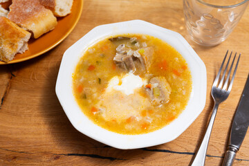 Appetizing rassolnik soup with sour pickles and pearl barley served in bowl
