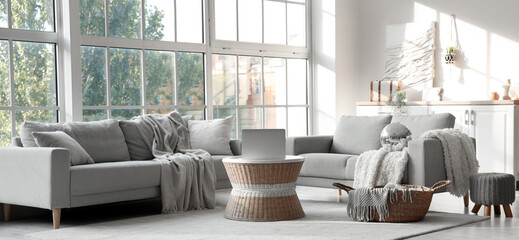 Interior of modern living room with disco ball, grey sofas and laptop on coffee table