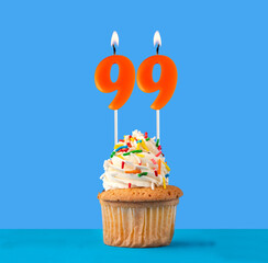 Orange candle number 99 - Birthday cupcake on blue background