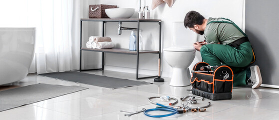 Plumber installing toilet bowl in bathroom
