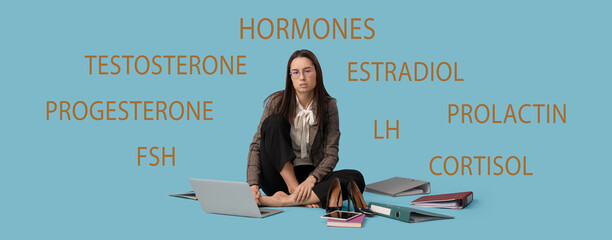 Tired young businesswoman with laptop and office folders sitting on blue background