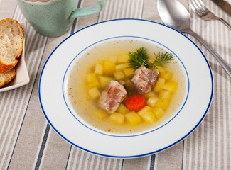 Bowl with just cooked meat soup served on table.