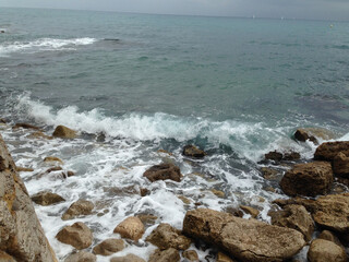 Scenic coastal view with turquoise sea waves crashing against rugged rocks. Perfect for nature, seascape, ocean, and coastal scenery