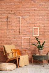 Interior of living room with armchair, houseplant and poufs