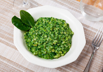 Delicious creamy orzotto with pearl barley and spinach. Italian style dish..