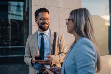 Business people having conversation on street using digital tablet and mobile phone