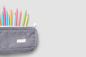 Case with many colorful pencils on grey background