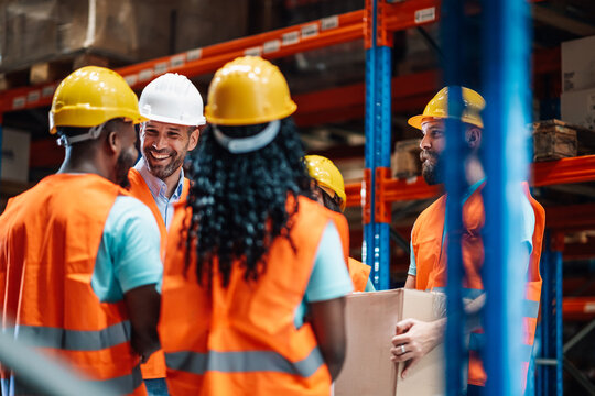 Warehouse workers and manager discussing logistics and operations