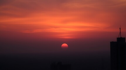 Obraz premium Fiery Sunset Cityscape Silhouette at Dusk
