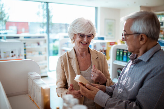 Elderly couple shopping for medication at pharmacy