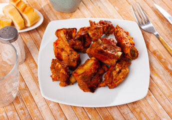 Appetizing fried pork ribs served on platter to table