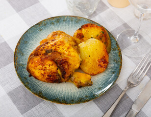 Grilled chicken with potatoes on side served on plate in restaurant