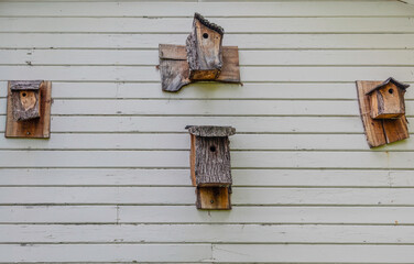 Four wooden bird houses on wall