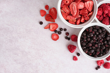 Bowls with tasty freeze-dried berries on light background
