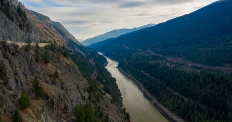 High-angle view of a river winding through a mountain valley. Trans Canada Highway and railway line hug the riverbank. Nature's beauty. Fraser River, Falls Creek, British Columbia, Canada