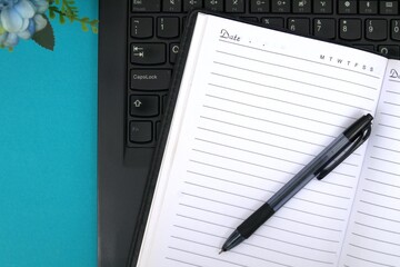 Note book, bolpoin on laptop keyboard