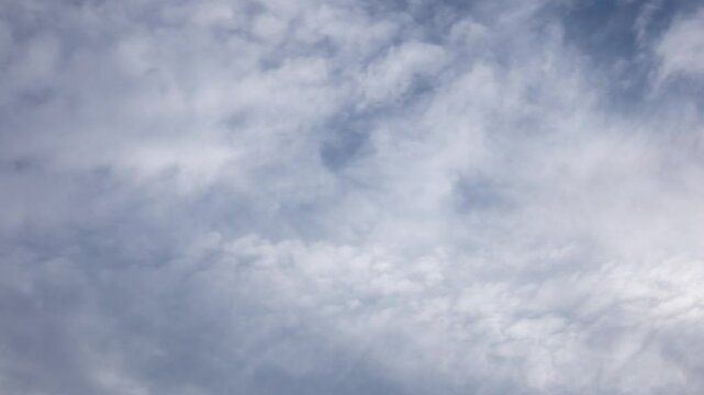 White clouds moving fast from right to left time-lapse. Daylight cloudy heaven background. Long timelapse light clouds transforming in blue sky with motion blur. Perfect for text, titles, logo