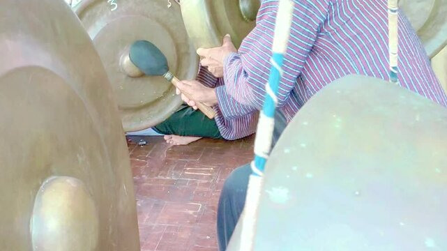 Cinematic shot. Hands of asian old men playing traditional musical instruments called Gamelan