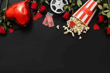 Bucket of popcorn with cinema tickets, film reel, red roses and air balloon in shape of heart on...