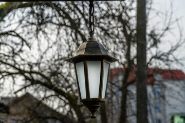 Old lantern hanging on the street, cozy warm autumn atmosphere