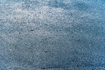 Wet asphalt close-up, background grey 