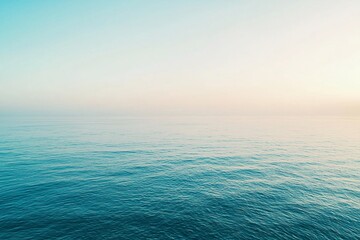 Obraz premium Serene ocean view at sunrise with calm waters reflecting pastel skies, perfect for relaxation themes