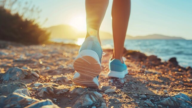 Woman strolling along a rocky beach at sunset in blue sneakers - Powered by Adobe