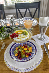 Fruit and Greek Yogurt breakfast with a slice of honey comb and golden berries