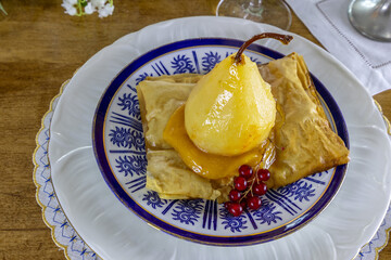 Pear poached in champagne and ginger on passionfruit curd and a puff pastry