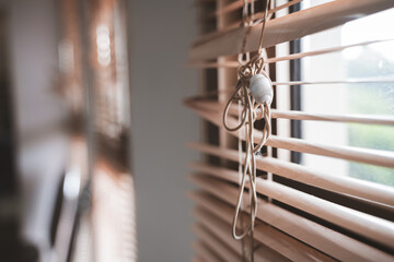 Close-ups of window blinds with a pull cord and partially broken blinds creating interesting light and shadow patterns.