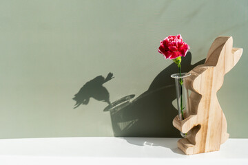 Minimalistic creative Easter concept. Two Easter bunnies under symbolic roof on green background. Celebration Easter holiday at home with family. Poster or greeting card. High quality photo