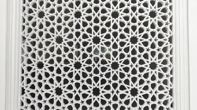 A building with Islamic geometric patterns as architectural elements for ventilation, lighting, and privacy, blocking outside views while enhancing aesthetics.