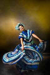 A woman in a blue dress with a flower on her head is dancing