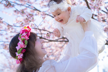 Obraz premium 桜を楽しむ赤ちゃんとお母さん