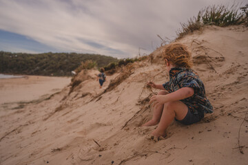 Toddler looking at person on beach sand dune