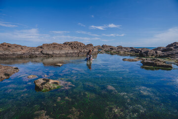 Family exploring water hole amongst rock pool
