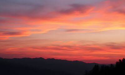 Fototapeta premium Orange sunset sky with distant mountain silhouettes. Perfect for nature-themed designs, travel brochures, outdoor adventure promotions, or inspirational content