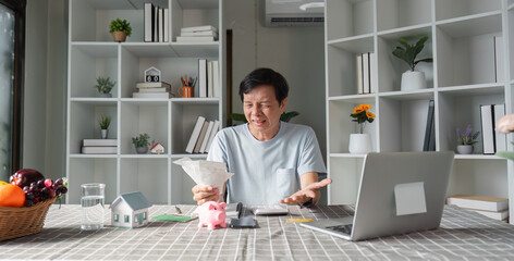 Fototapeta premium Distraught man overwhelmed by financial problems and expenses while reviewing bills at home office