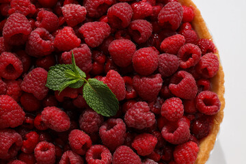 Berry pie with raspberries, blueberries and mint leaves on white background, close up