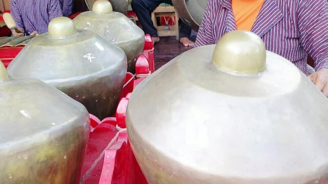 Cinematic shot. Hands of asian old men playing traditional musical instruments called Gamelan