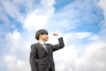 拳を握るビジネスマンと青空