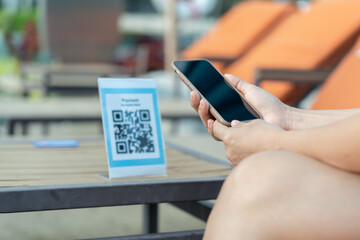 Woman use smartphone to scan QR code for order menu in cafe restaurant with a digital delivery. Choose menu and order accumulate discount. E wallet, technology, pay online, credit card, bank app.