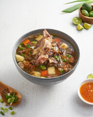 A delicious meat soup, featuring tender meat, potatoes, carrots, and green onions, accompanied by...
