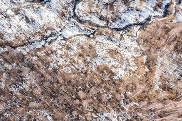 snow-covered marshlands area in early spring. aerial top view from flying drone.