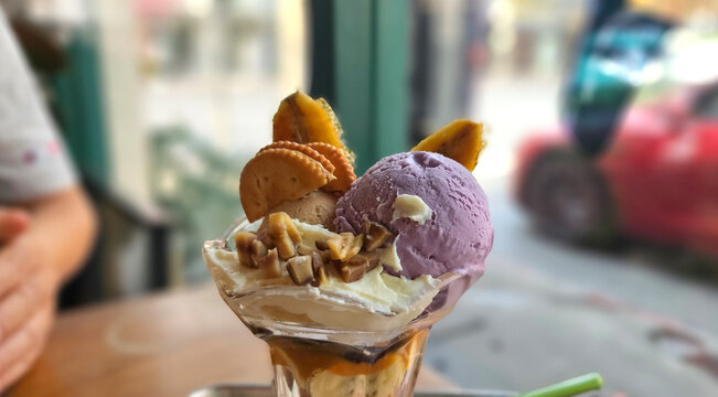 Thai style sweet potato homemade ice cream serving with wiped cream, chestnut, cracker, and banana