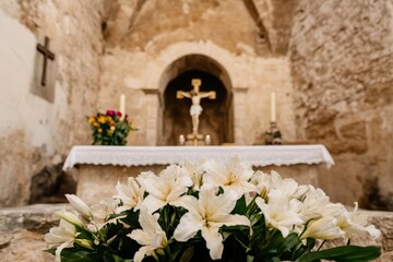 Candle lit altar with flowers and decorative Easter eggs.