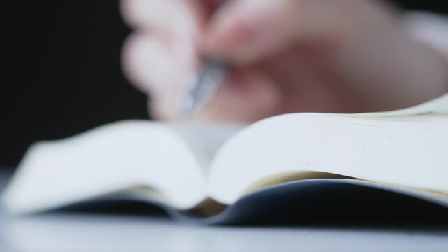 テキストとペンで勉強する人の手元
