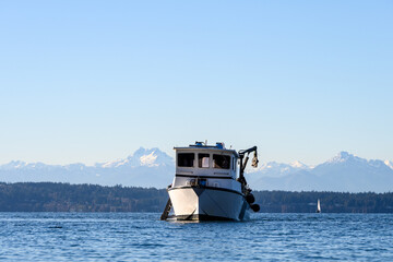 Scuba dive boat on calm Puget Sound waters with the Olympic Mountain Range in the background,...