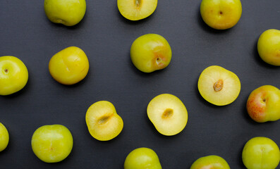 Fresh green plum fruit on dark background.