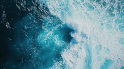 Aerial view of ocean waves crashing with white foam creating dynamic textures and shades of blue